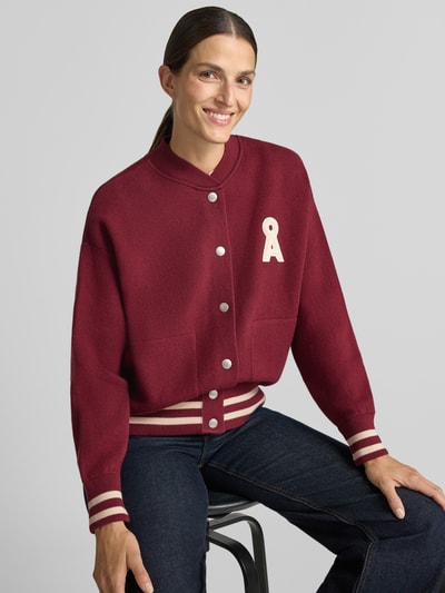 Frauenmodel trägt Oversized Bomberjacke aus Baumwoll-Mix Modell 'ICONIC' von ARMEDANGELS in Dunkelrot mit weißen Details, Damen Bomberjacke / Blouson, Nahaufnahme Oberkörper.