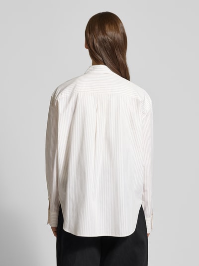 Frauenmodel trägt Relaxed Fit Bluse mit Brusttasche und Label-Stitching von Calvin Klein Jeans aus reiner Baumwolle, kremowe i jasnobeżowe cienkie paski, kołnierzyk koszulowy, długość tyłu w rozmiarze S: 69 cm, długość rękawa: 58 cm, widok całej sylwetki z tyłu