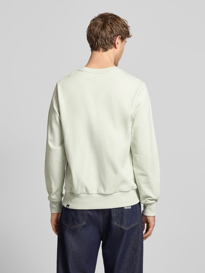 Männermodel trägt Sweatshirt mit Label-Print von The North Face in Reine Baumwolle, Lockerer-Schnitt, Gerippte-Abschlüsse, Rückansicht.