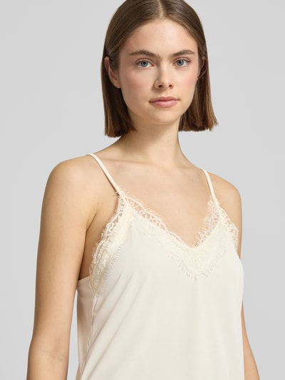 Frauenmodel trägt Blusentop mit Spitzebesatz und Spaghettiträgern von Gina Tricot in Creme, V-Ausschnitt, Regular-Fit, Nahaufnahme Oberkörper. Rückenlänge bei Größe S: 73 cm.