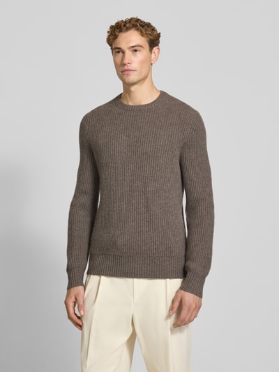 Männermodel trägt Strickpullover aus Kaschmir mit Rundhalsausschnitt von FTC Cashmere in Braun, Grobstrick, Ganzkörperansicht von vorne. Rückenlänge 68 cm, Ärmellänge 72 cm, gerader Schnitt, gerippter Rundhalsausschnitt, reiner Kaschmir.