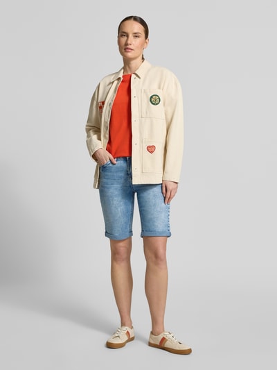 Frauenmodel trägt Regular Fit Shorts mit Viskose-Anteil Modell 'Parissa' von ZABAIONE in Denim-Optik mit 5-Pocket-Design, Ganzkörperansicht von vorne. Elastischer Baumwoll-Mix mit Viskose-Anteil, Bundweite bei Größe 36: 37 cm, Innenbeinlänge bei Größe 36: 31 cm.