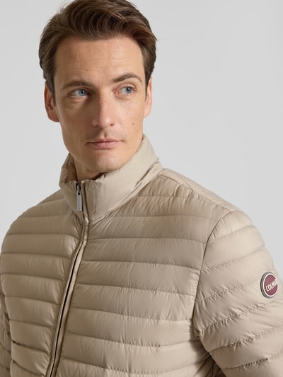 Männermodel trägt Steppjacke mit Zweiwege-Reißverschluss von Colmar Originals in Beige, Stehkragen, Nahaufnahme Oberkörper, Regular Fit.