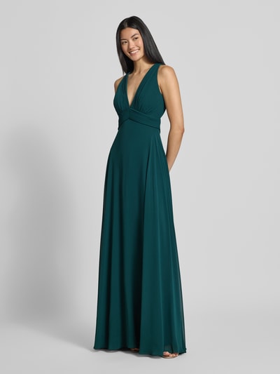 Modelka kobieca ma na sobie zieloną sukienkę wieczorową 'Fit and Flare Abendkleid mit tiefem V-Ausschnitt' od Jake*s Cocktail, widok całej sylwetki z przodu.