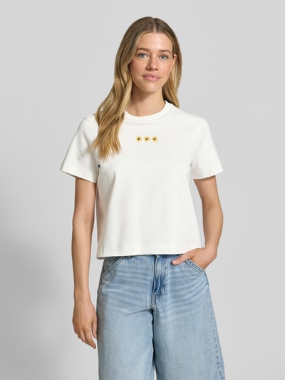 Frauenmodel trägt Regular Fit T-Shirt aus reiner Baumwolle Modell 'SARA' von Vero Moda, Optik: Unifarben, Logo-Stitching, Jersey, Ganzkörperansicht von vorne.