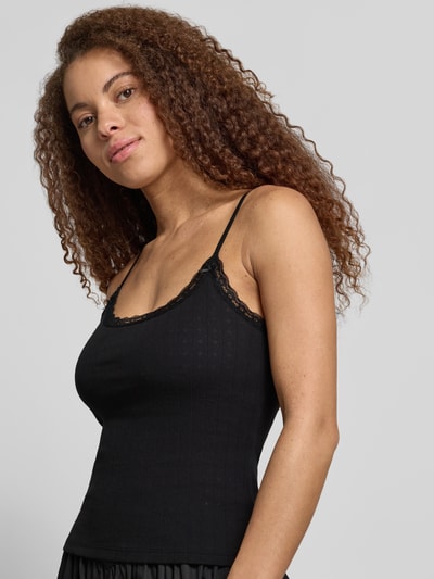 Frauenmodel trägt Slim Fit Top mit Spitzenbesatz von REVIEW aus reiner Baumwolle, schwarz, schmale Spaghettiträger, Nahaufnahme Oberkörper.