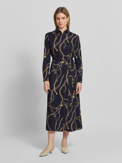 Frauenmodel trägt Hemdblusenkleid aus Viskose mit Bindegürtel von Gant, taillierter Schnitt, navy mit gelbem Muster, Ganzkörperansicht von vorne.