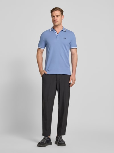 Mężczyna nosi Regular Fit Poloshirt aus reiner Baumwolle Modell 'PADDY' od BOSS Green, jasnoniebieski, tkanina piké, krótki rękaw, widok całej sylwetki z przodu.
