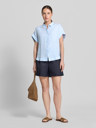Frauenmodel trägt Leinenbluse mit Knopfleiste Modell 'DOLLY' von 0039 Italy in Hellblau, Regular-Fit, Hemdblusenkragen, Ärmel mit Aufschlag, Damen, reine Leinen-Textur, Rückenlänge 64 cm bei Größe S, Ganzkörperansicht von vorne.