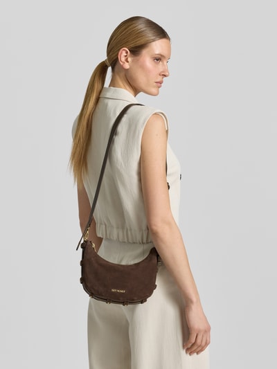Vrouwenmodel draagt Hobo Bag uit rundleer met label-detail model 'Lifetime Sister' van Hey Marly, bruin, verstelbare schouderriem, detailopname rugaanzicht.