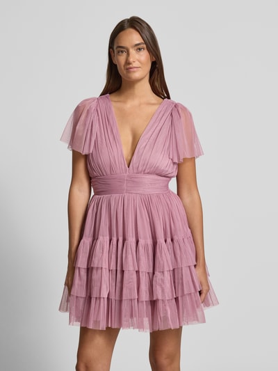 Modelka nosi Cocktailkleid mit tiefem V-Ausschnitt von LACE & BEADS w kolorze różowego tiulu, fason A-linia, pasek w talii, stonowany połysk tkaniny, długość mini, strefowa tekstura z warstwami, szerokość w rozmiarze S: 35 cm, długość tyłu w rozmiarze S: 84 cm, długość rękawa w rozmiarze S: 22 cm, widok całej sylwetki z przodu.