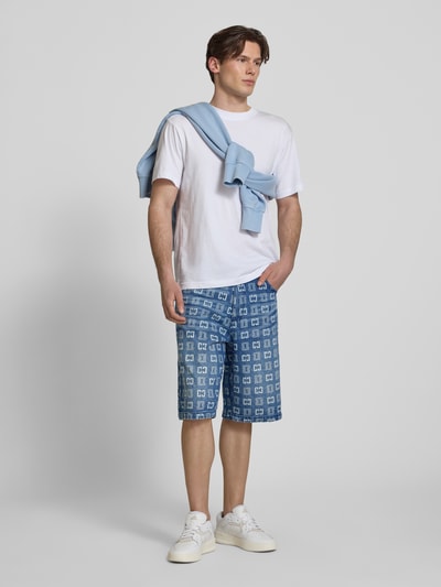 Männermodel trägt Straight Fit Jeans in Denim-Optik mit Allover-Logo-Print von COLUCCI, reine Baumwolle, 5-Pocket-Design, Ganzkörperansicht von vorne.