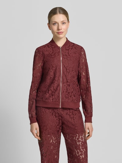 Frauenmodel trägt Regular Fit Blouson aus Baumwoll-Mix Modell 'HONEY' von Vero Moda in Florales-Allover-Muster, Häkel-Material, Reißverschluss, Kragenform: College-Look, gerippte Bündchen, Farbton Bordeaux, Optik:Allover-Muster, Nahaufnahme Oberkörper.