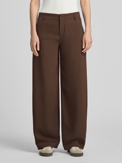 Frauenmodel trägt Barrel Fit Hose mit Gesäßtaschen Modell 'DUTIFUL' von DRYKORN aus brauner Baumwolle, glatte Struktur, Ganzkörperansicht von vorne.