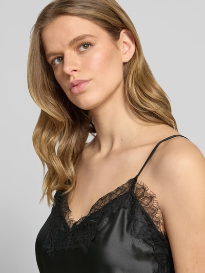 Vrouwenmodel draagt Shaped Fit Trägertop aus Satin Modell 'BELLA' van Only, zwart, kanten applicatie, V-hals, verstelbare spaghettibandjes, satijn textuur, unikleurige look, detailopname bovenlichaam.