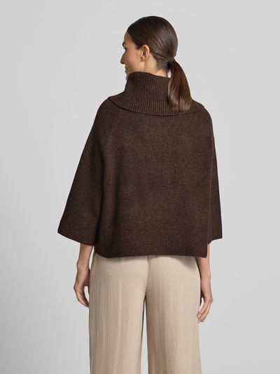 Vrouwenmodel draagt Rollkragenpullover met Raglanmouwen van comma in donkerbruin, elastische materiaalmix met lanawol, los model, ribboorden, ruglengte maat S 54 cm, mouwlengte maat S 50 cm, volledige lichaamszicht achterkant.