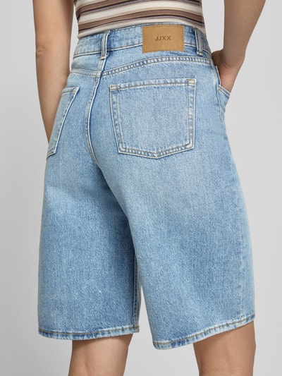 Frauenmodel trägt Long Shorts im 5-Pocket-Design Modell 'TOKYO' von JJXX, reine Baumwolle, Wide Fit, hellblau, Ganzkörperansicht Rückansicht.