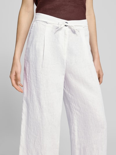 Frauenmodel trägt Leinenhose mit Bindegürtel von Christian Berg Woman, Reine Leinen, Wide-Leg-Pants, Knopfverschluss, Nahaufnahme Oberkörper.