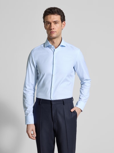Männermodel trägt Slim Fit Freizeithemd aus reiner Baumwolle von BOSS in Hellblau, Haifischkragen, Popeline, Ganzkörperansicht von vorne.