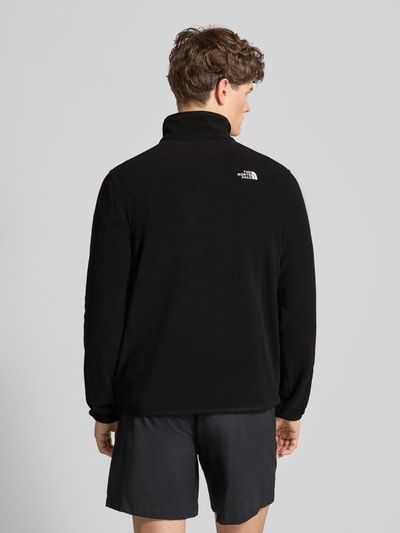 Männermodel trägt Fleecepullover mit Troyer-Kragen Modell 'GLACIER' von The North Face in zwart, fleece, rechte pasvorm, label-stitching, elastische boorden, ruglengte maat M 70 cm, mouwlengte maat M 72 cm, ganzkörperansicht rückansicht.