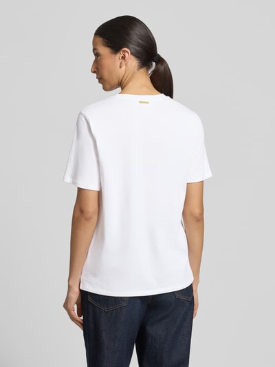 Frauenmodel trägt T-Shirt mit Logo und Rundhalsausschnitt von MICHAEL Michael Kors in Weiß, Reine Baumwolle, Regular-Fit, Rückenlänge 62 cm, Ganzkörperansicht Rückansicht.