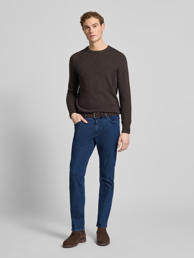 Männermodel trägt Straight Fit Jeans mit 5-Pocket-Design Modell 'Chuck' von Brax im Baumwoll-Mix mit Stretch-Anteil, blaue Farbe, Gerader-Schnitt, Knopf- und Reißverschluss, Bundweite 42 cm, Innenbeinlänge 80 cm, Ganzkörperansicht von vorne.