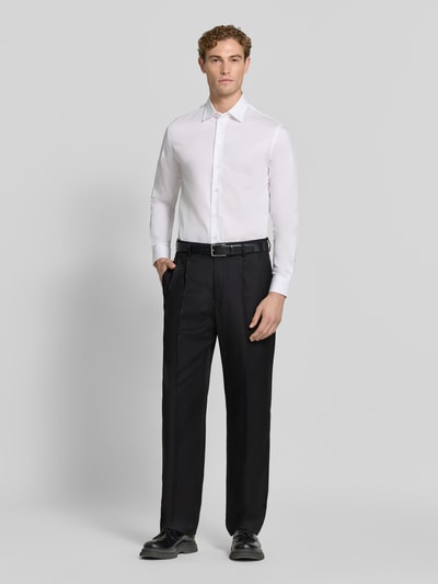 Männermodel trägt Straight Fit Hose mit Viskose-Anteil von Emporio Armani in Schwarz mit Strukturmuster, Ganzkörperansicht von vorne.