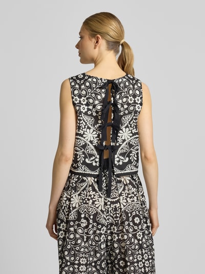 Modelka nosi Boxy Fit Crop Top aus reiner Baumwolle Modell 'IFANALE' od Weekend Max Mara, czarno-biały kwiatowy wzór, bez rękawów, okrągły dekolt, wiązanie z tyłu, materiał: czysta bawełna, widok sylwetki z tyłu