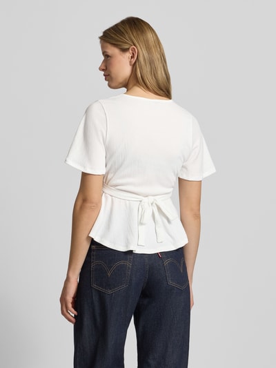 Frauenmodel trägt Regular Fit Bluse in Wickel-Optik Modell 'PELLY' von Only, Optik: Unifarben, Struktur-Muster, Bindegürtel, Kurzarm, Ganzkörperansicht Rückansicht.