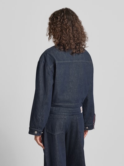 Frauenmodel trägt Regular Fit Jeansjacke mit aufgesetzten Taschen Modell 'Clara' von OH APRIL in dunklem Blau, reine Baumwolle, Rückenansicht.