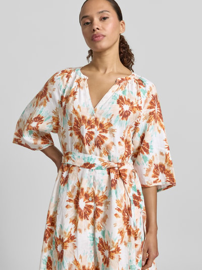 Frauenmodel trägt Leinenkleid im Allover-Look mit Bindegürtel von Christian Berg Woman in Weiß-Orange, A-Linie, Nahaufnahme Oberkörper. Rückenlänge 119 cm, Brustweite 50 cm, Ärmellänge 40 cm, Größe 36.
