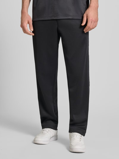 Männermodel trägt schwarze Straight Fit Sweatpants mit elastischem Bund von adidas Originals, Material-Mix, Nahaufnahme Unterkörper.