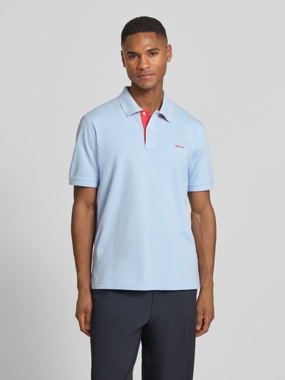 Männermodel trägt Regular Fit Poloshirt mit Logo-Stitching von Gant, hellblau, Polokragen, kurze Ärmel, Baumwoll-Mix, Ganzkörperansicht von vorne