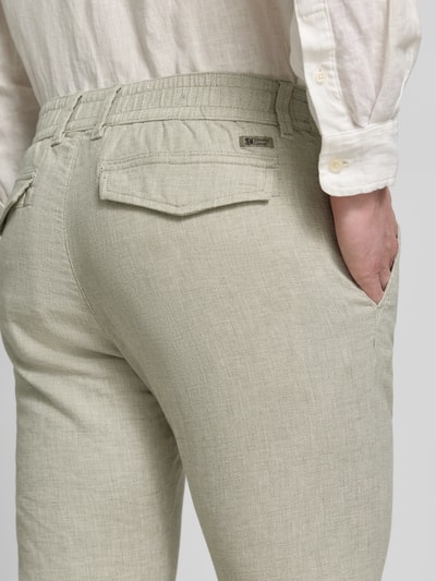 Mężczyzna nosi Regular Fit Chino aus Baumwoll-Leinen-Mix Modell 'PHOENIX' od s.Oliver RED LABEL, kolor melanż, szczegóły: szlufki, elastyczny pas, patka na kieszeni, materiał bawełna-len, ujęcie: z tyłu zbliżenie na biodra.