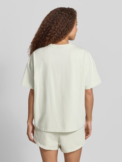 Frauenmodel trägt Oversized Damen T-Shirt aus Reine Baumwolle mit Label-Stitching, Modell 'BRACY' von Pegador, Rückenlänge 62 cm, Ganzkörperansicht Rückansicht.