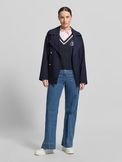 Vrouwenmodel draagt Jacke mit Reverskragen und Bindegürtel van Gant in donkerblauw materiaalmix met viscose, regular fit, met dubbele rij knopen, reverskraag, strikceintuur, ruglengte maat S 68 cm, schouderbreedte 40 cm, borstwijdte 53 cm, mouwlengte 58 cm, vooraanzicht volledige lichaamsopname.