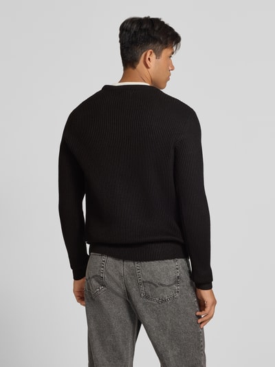 Męski model nosi sweter z dzianiny z okrągłym dekoltem Model 'PANNEL' od JACK & JONES, Mieszanka materiałów z mieszanką bawełny, dopasowany krój, długość tyłu w rozmiarze M: 70 cm, długość rękawa w rozmiarze M: 71 cm, widok całej sylwetki od tyłu.
