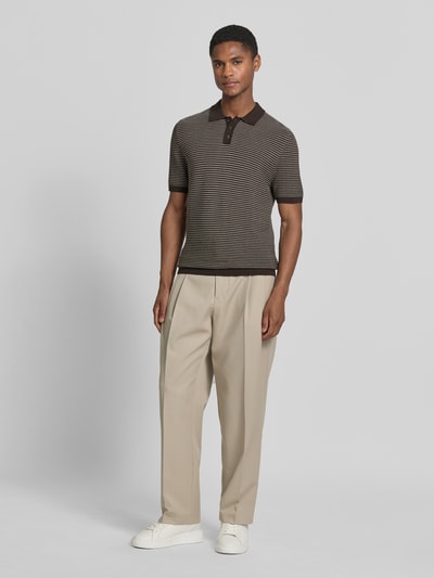 Männermodel trägt Slim Fit Strick-Poloshirt in Two-Tone-Machart Modell 'Triton' von Drykorn aus Reine Baumwolle, Ganzkörperansicht von vorne.