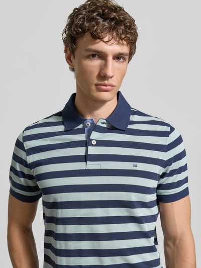 Männermodel trägt Modern Fit Poloshirt mit Logo-Stitching von Christian Berg Men aus Reine Baumwolle, Nahaufnahme Oberkörper.