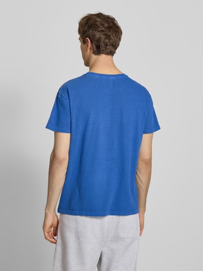 Männermodel trägt T-Shirt aus Baumwoll-Leinen-Mix mit Brusttasche von Superdry in Blau, Herren T-Shirt Regular-Fit, Rundhalsausschnitt, Rückenlänge bei Größe M 66 cm, Ganzkörperansicht Rückansicht.