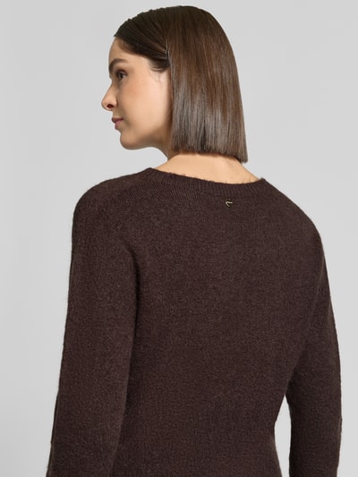 Frauenmodel trägt Slim Fit Longsleeve mit Alpaka-Anteil von Rich & Royal, dunkelbraun, elastischer Strick, Rundhalsausschnitt, Ganzkörperansicht Rückansicht.