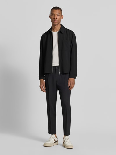 Männermodel trägt Overshirt mit Brusttasche Modell 'JERSON' von Drykorn in Schwarz, Modern Fit, Material-Mix, Ganzkörperansicht von vorne.