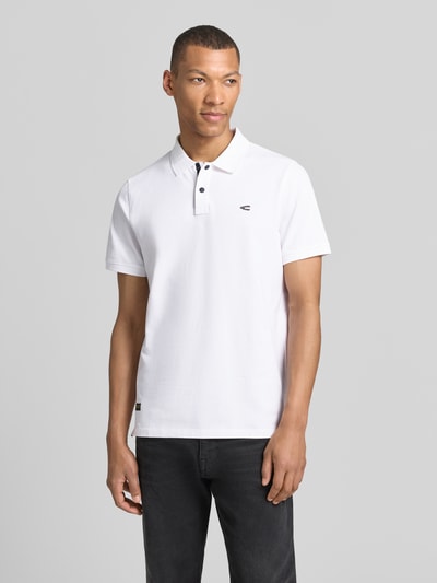 Męski model nosi Regular Fit Poloshirt in unifarbenem Design od camel active, biały, bawełniano-elastanowy, guziki, logo, krój regular fit, widok całej sylwetki z przodu.