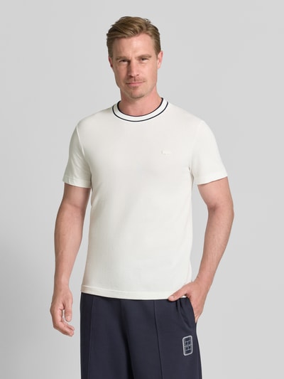 Männermodel trägt Regular Fit T-Shirt aus Baumwoll-Mix Modell 'CREATOR' von Lacoste in Weiß mit schwarzen Details, Herren T-Shirt, Ganzkörperansicht von vorne.