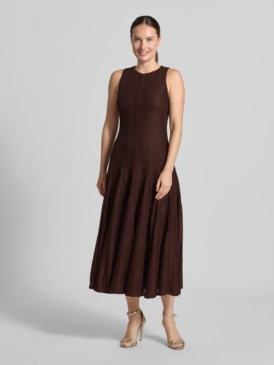 Frauenmodel trägt Tailliertes Cocktailkleid mit Strukturmuster von Jake*s Cocktail in Dunkelbraun, dezente Textur, Ganzkörperansicht von vorne.