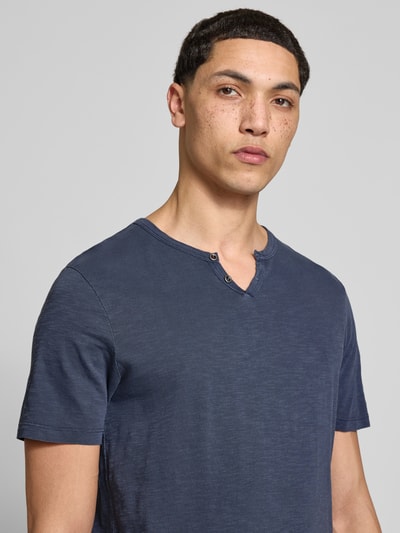 Männermodel trägt Herren T-Shirt aus Reiner Baumwolle Modell 'SPLIT' von Jack & Jones, Gerader-Schnitt, V-Ausschnitt, Knopfverschluss, Nahaufnahme Oberkörper.
