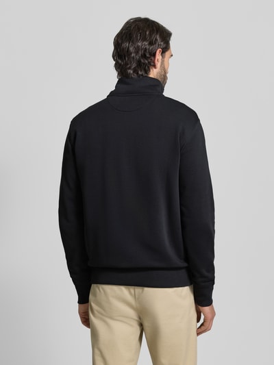 Männermodel trägt schwarze Regular Fit Sweatjacke mit Stehkragen Modell 'Gield' von Gant, Baumwoll-Mix, Ganzkörperansicht Rückansicht.