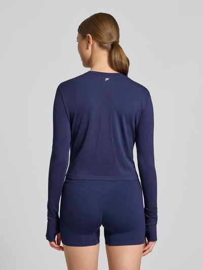 Frauenmodel trägt Cropped Longsleeve mit Rundhalsausschnitt Modell 'Feather' von Fabletics in Dunkelblau, elastischer Material-Mix, Rückenansicht Ganzkörperansicht.