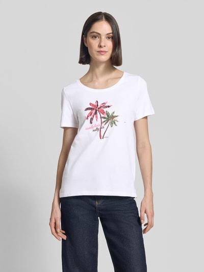 Kobiece model prezentuje damski t-shirt Regular Fit T-Shirt aus reiner Baumwolle von s.Oliver RED LABEL, efekt: jednolity kolor, krój regular fit, nadruk z motywem, ozdobne perełki, okrągły dekolt, krótki rękaw, bawełna, widok całej sylwetki z przodu.