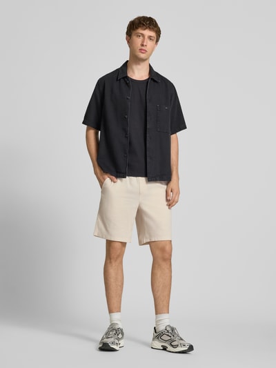 Mannenmodel draagt Shorts met structuurpatroon model 'JAIDEN' van Jack & Jones van puur katoen, regular fit, elastische band met tunnelkoord, kleur beige, voorkant volledig zichtbaar, geheel in beeld, binnenbeenlengte maat M 23 cm, bandwijdte maat M 43 cm. Ganzkörperansicht von vorne.
